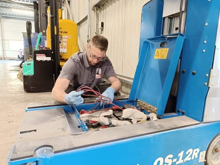 Image d'un technicien en train de réaliser la régénération d'une batterie de chariot élévateur.