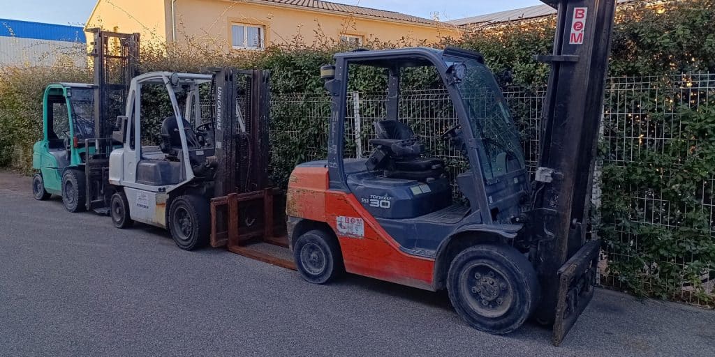 Image de 3 chariots élévateurs parqués