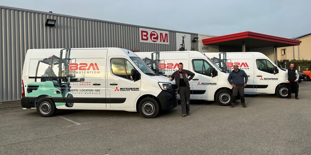 Image de 3 techniciens de maintenance devant le siège de B2M Manutention