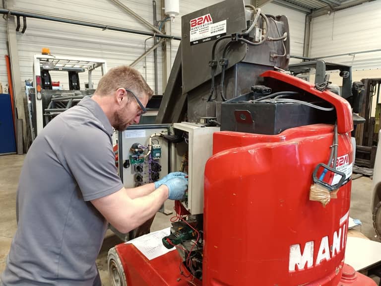 Image d'un technicien SAV réalisant la maintenance d'une nacelle élévatrice Manitou