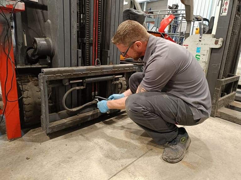 Image d'un technicien de maintenance B2M Manutention qui réalise le remplacement d'un accessoire de manutention