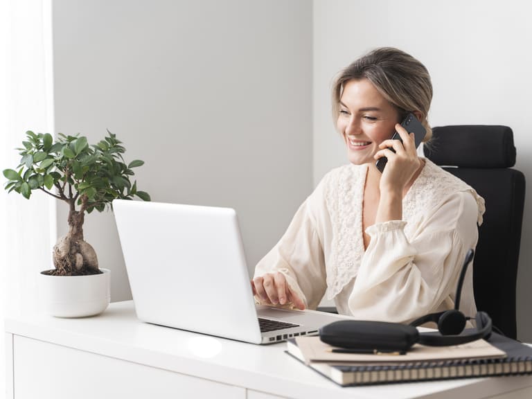 Image d'une femme derrière son bureau au téléphone